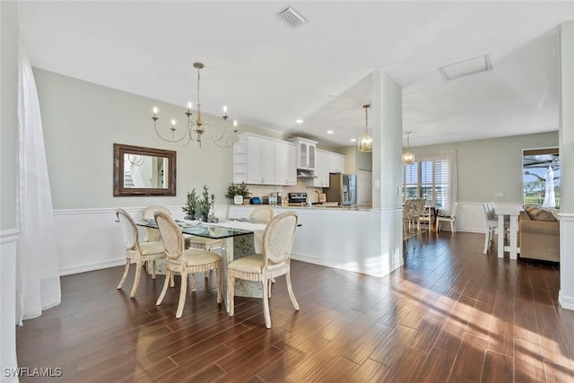 dining space with dark wood-type flooring and a notable chandelier