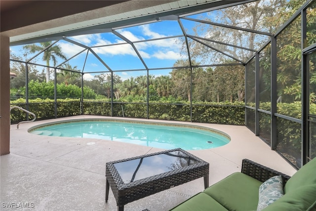 view of swimming pool featuring a patio area and glass enclosure