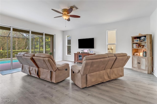 living room with light hardwood / wood-style floors and ceiling fan