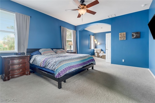 carpeted bedroom featuring multiple windows and ceiling fan