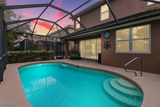 pool at dusk featuring a patio area and a lanai