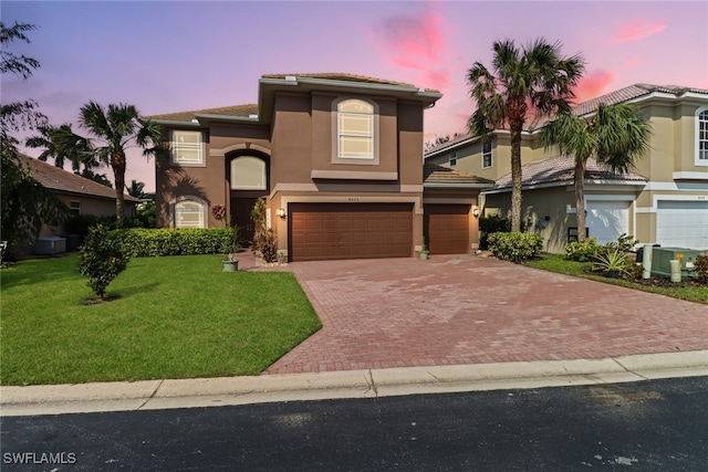 mediterranean / spanish-style house featuring a lawn and a garage