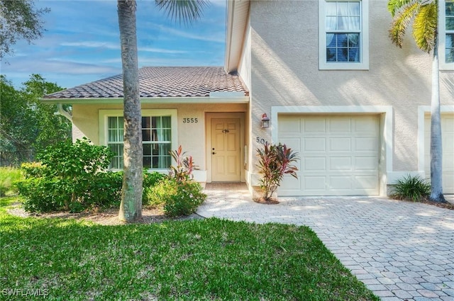 3555 Avion Woods Ct Unit 501, Naples, FL 34104 - view of front facade with stucco siding, decorative driveway, a tile roof, and a garage