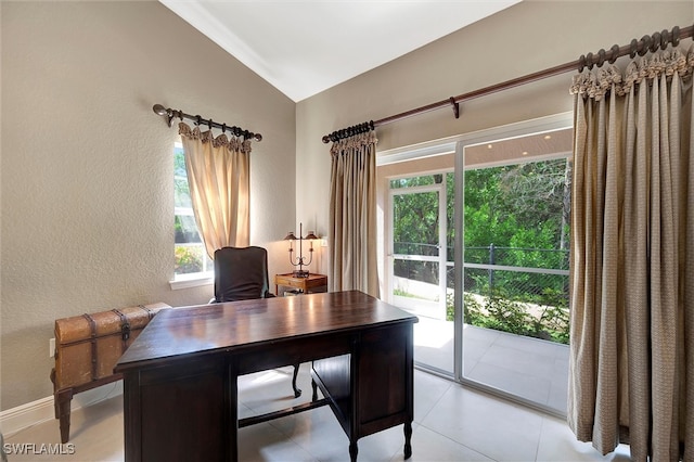 tiled office space featuring lofted ceiling