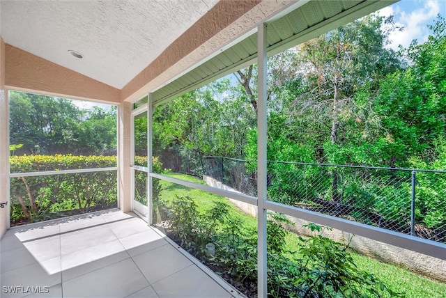 unfurnished sunroom featuring vaulted ceiling