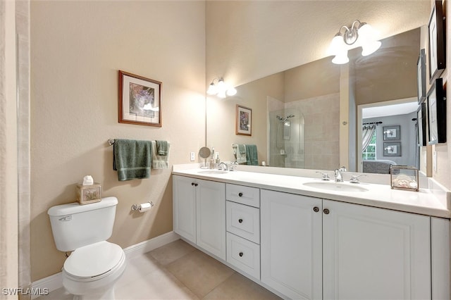 bathroom with vanity, tiled shower, toilet, and tile patterned flooring