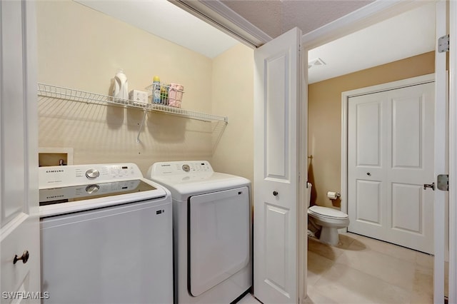 laundry room featuring washer and clothes dryer and a textured ceiling