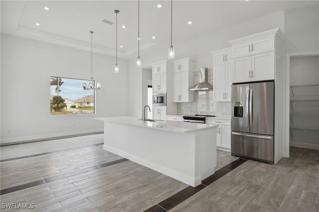 kitchen with a center island with sink, white cabinets, and stainless steel appliances