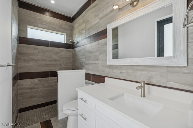 bathroom with hardwood / wood-style floors, a shower, tile walls, toilet, and vanity