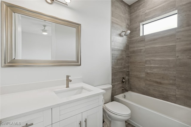 full bathroom featuring vanity, tiled shower / bath combo, and toilet