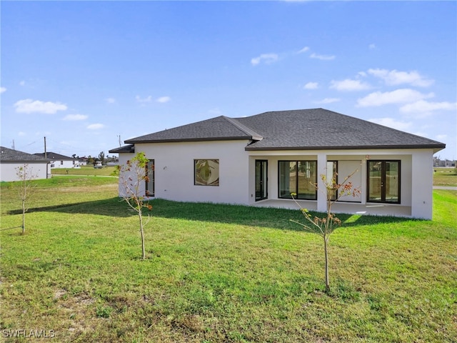 back of property with a patio area and a lawn