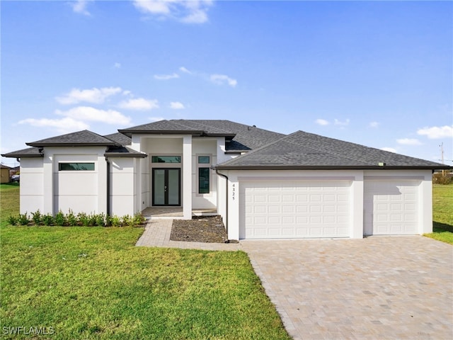 prairie-style home featuring a front yard and a garage