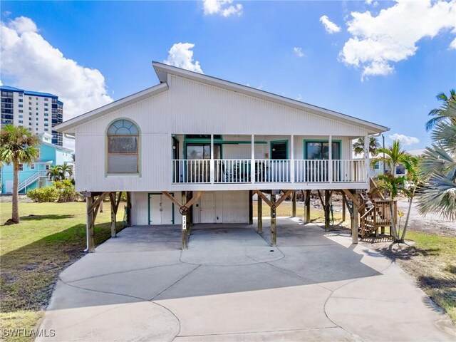 coastal home featuring covered porch and a carport