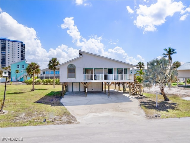 view of front facade with a front yard, a carport, and a porch