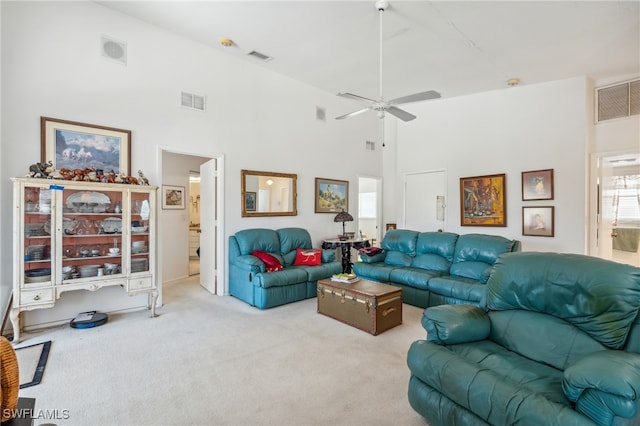 living room featuring a high ceiling, light carpet, and ceiling fan