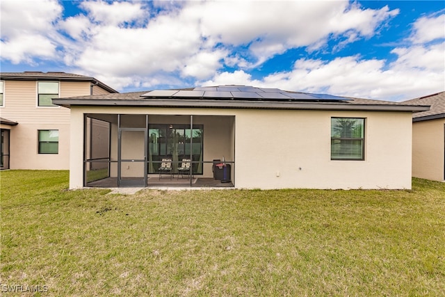 rear view of house with a patio area, solar panels, a yard, and a sunroom