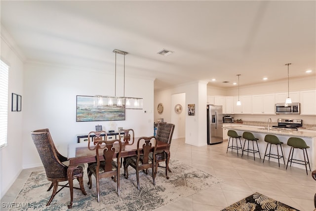 tiled dining space with crown molding and sink