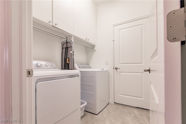 clothes washing area featuring washer and dryer and cabinets