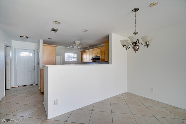 kitchen featuring light brown cabinets, ceiling fan with notable chandelier, light tile patterned floors, decorative light fixtures, and kitchen peninsula