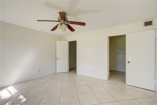 spare room with ceiling fan and light tile patterned flooring