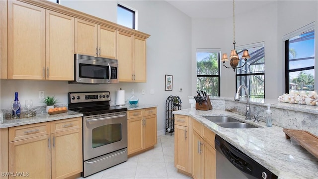 kitchen featuring light brown cabinets, sink, stainless steel appliances, and an inviting chandelier