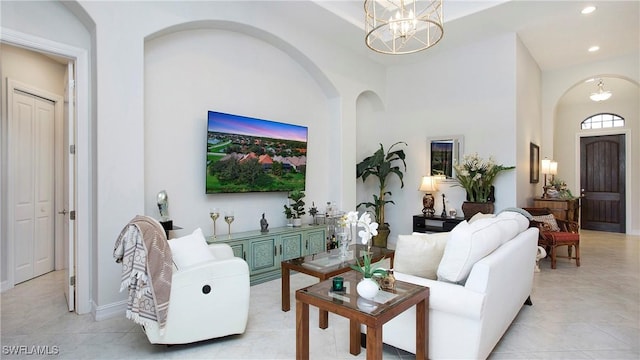 living room featuring a high ceiling, light tile patterned floors, and a notable chandelier