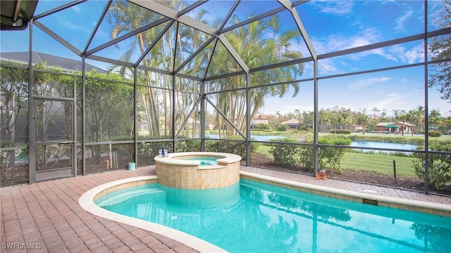 view of swimming pool with an in ground hot tub, a water view, glass enclosure, and a patio area