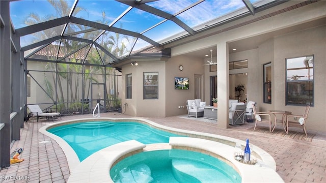 view of pool featuring an in ground hot tub, an outdoor living space, glass enclosure, and a patio area