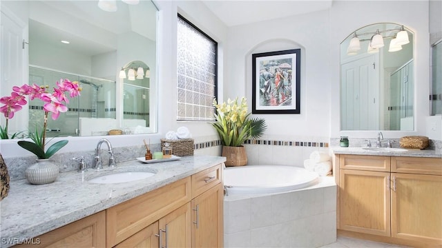 bathroom featuring vanity and independent shower and bath