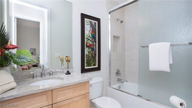 full bathroom with vanity, enclosed tub / shower combo, and toilet