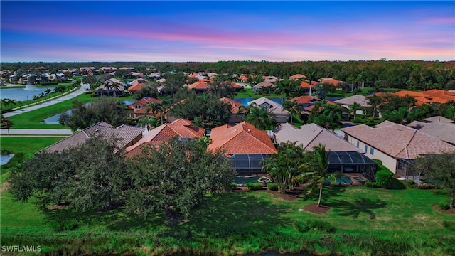 aerial view at dusk featuring a water view