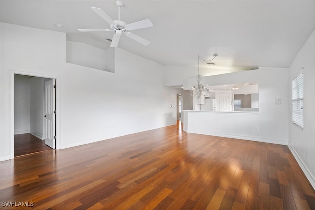 unfurnished living room with ceiling fan with notable chandelier, high vaulted ceiling, and dark hardwood / wood-style floors