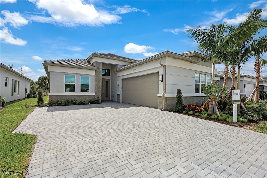 12216 Lotus Ave, Naples, FL 34120 - prairie-style home featuring a garage