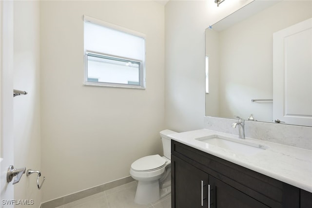 bathroom with toilet, vanity, and tile patterned floors