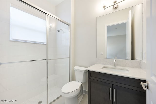 bathroom featuring vanity, toilet, and a shower with shower door