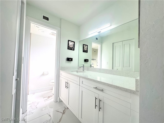 bathroom featuring vanity and toilet