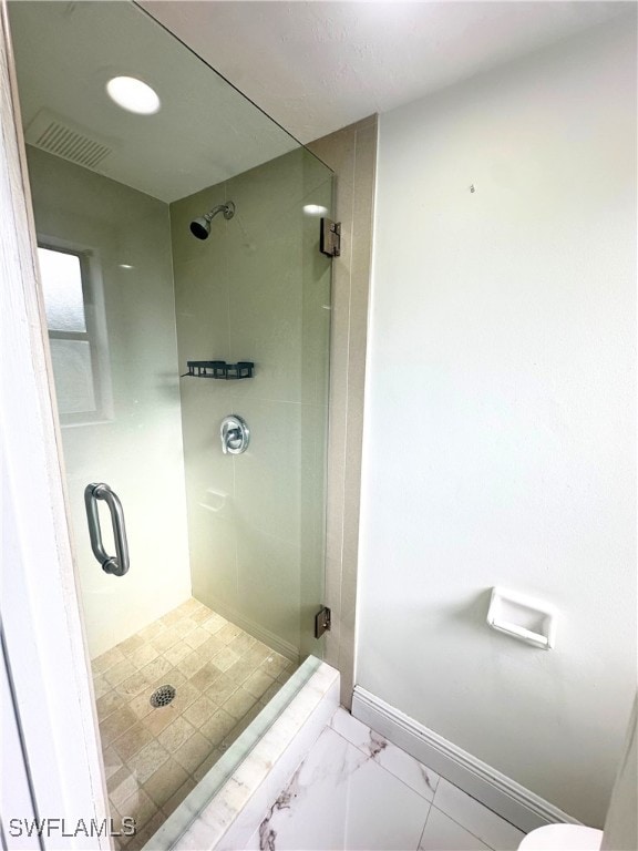 bathroom featuring a shower with door