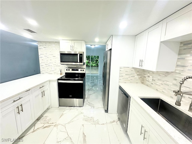 kitchen featuring white cabinetry, stainless steel appliances, sink, and tasteful backsplash