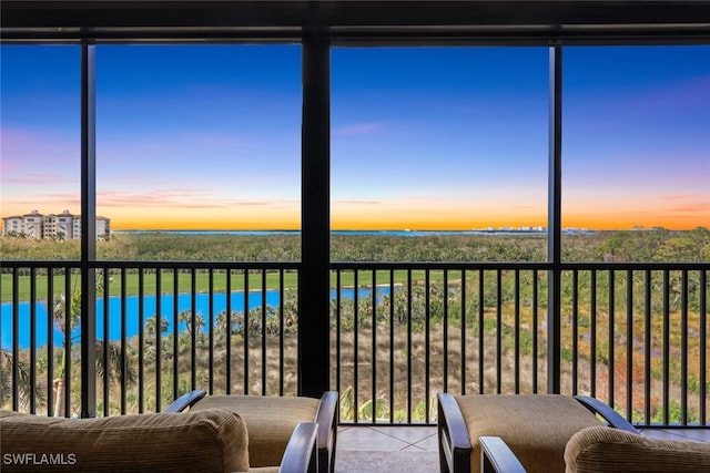 unfurnished sunroom featuring a water view