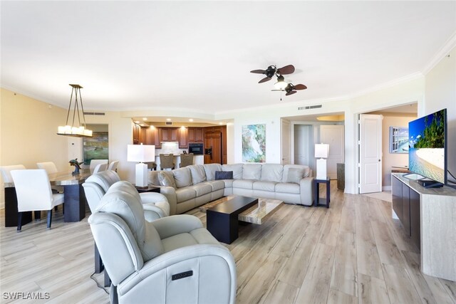 living room with ceiling fan, ornamental molding, and light hardwood / wood-style flooring