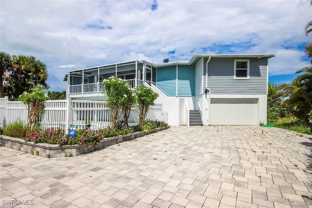 view of front of home with a garage and a sunroom