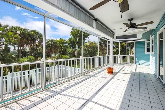 unfurnished sunroom with ceiling fan