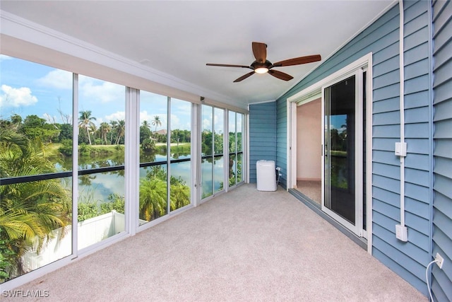 unfurnished sunroom featuring a water view and ceiling fan