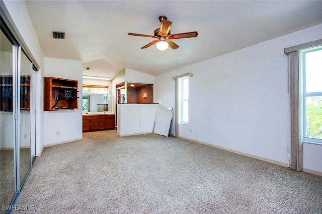 unfurnished living room with vaulted ceiling, light carpet, and ceiling fan