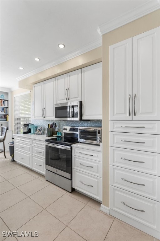 kitchen with white cabinetry, crown molding, decorative backsplash, light tile patterned floors, and appliances with stainless steel finishes