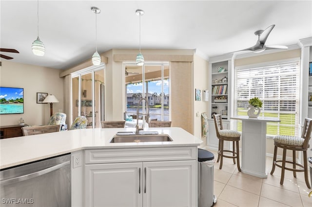 kitchen featuring hanging light fixtures, stainless steel dishwasher, white cabinets, a sink, and ceiling fan