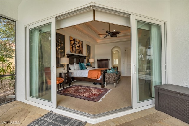 exterior space with a tray ceiling and light tile patterned floors