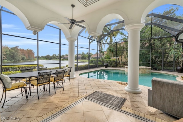 view of pool with a water view, ceiling fan, glass enclosure, and a patio