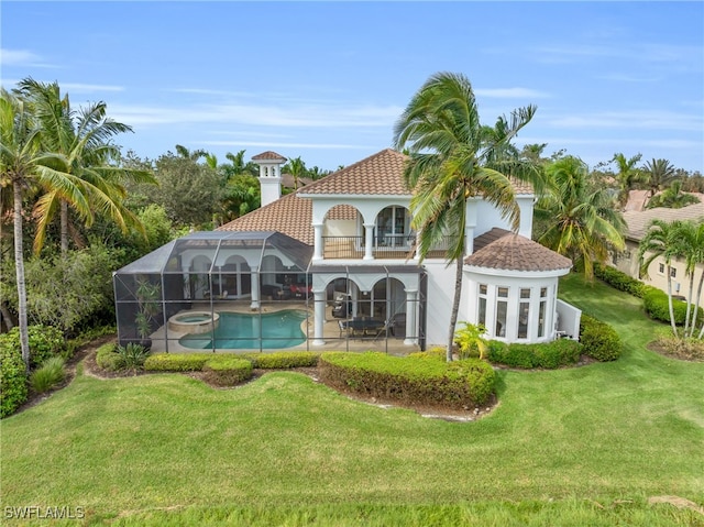 rear view of property featuring a patio, glass enclosure, a balcony, and a lawn