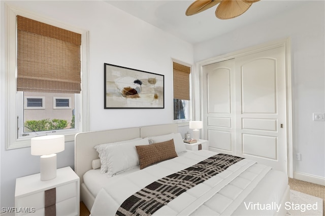 bedroom with a closet, ceiling fan, carpet, and multiple windows